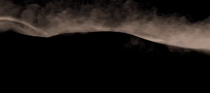 Fine sand blowing off the crest of a distant dune, on black