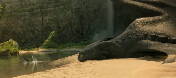 Little splashes in the shallows beside a dragon lying on the beach