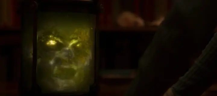 A ghostly glowing face inside a glass jar